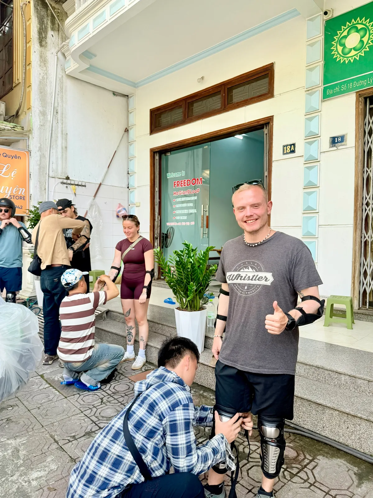 Freedom staff fitting knee and elbow pads on guests outside the Ha Giang office