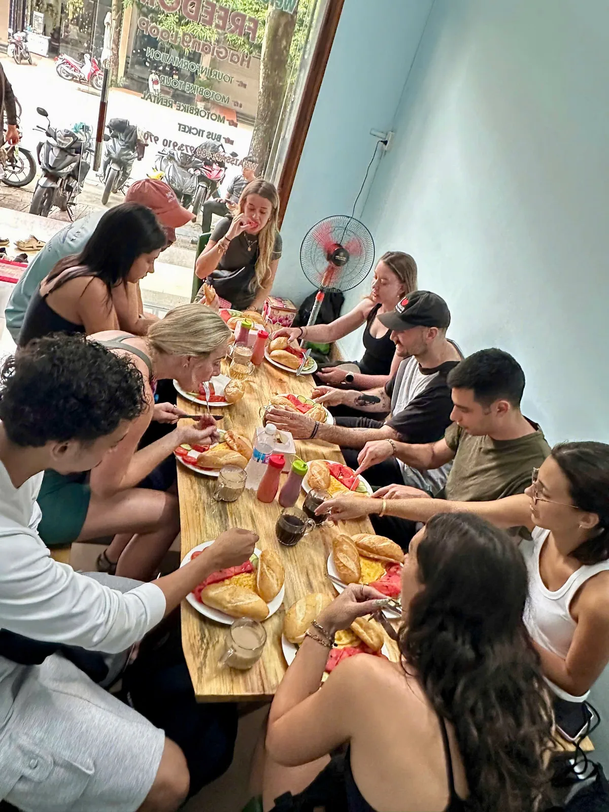 Group breakfast with baguettes, eggs, watermelon and coffee at the Freedom Ha Giang Loop base