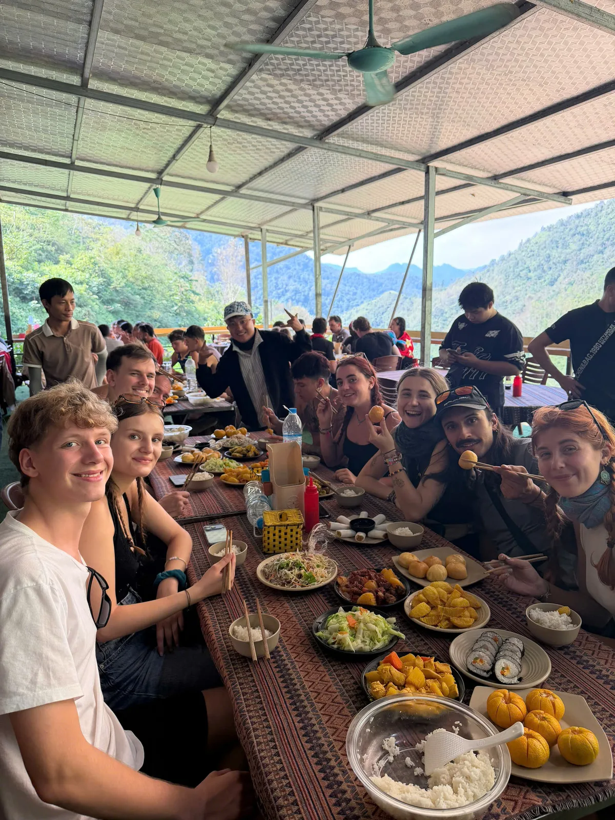 Freedom guests sharing a long lunch table with mountain views in Ha Giang