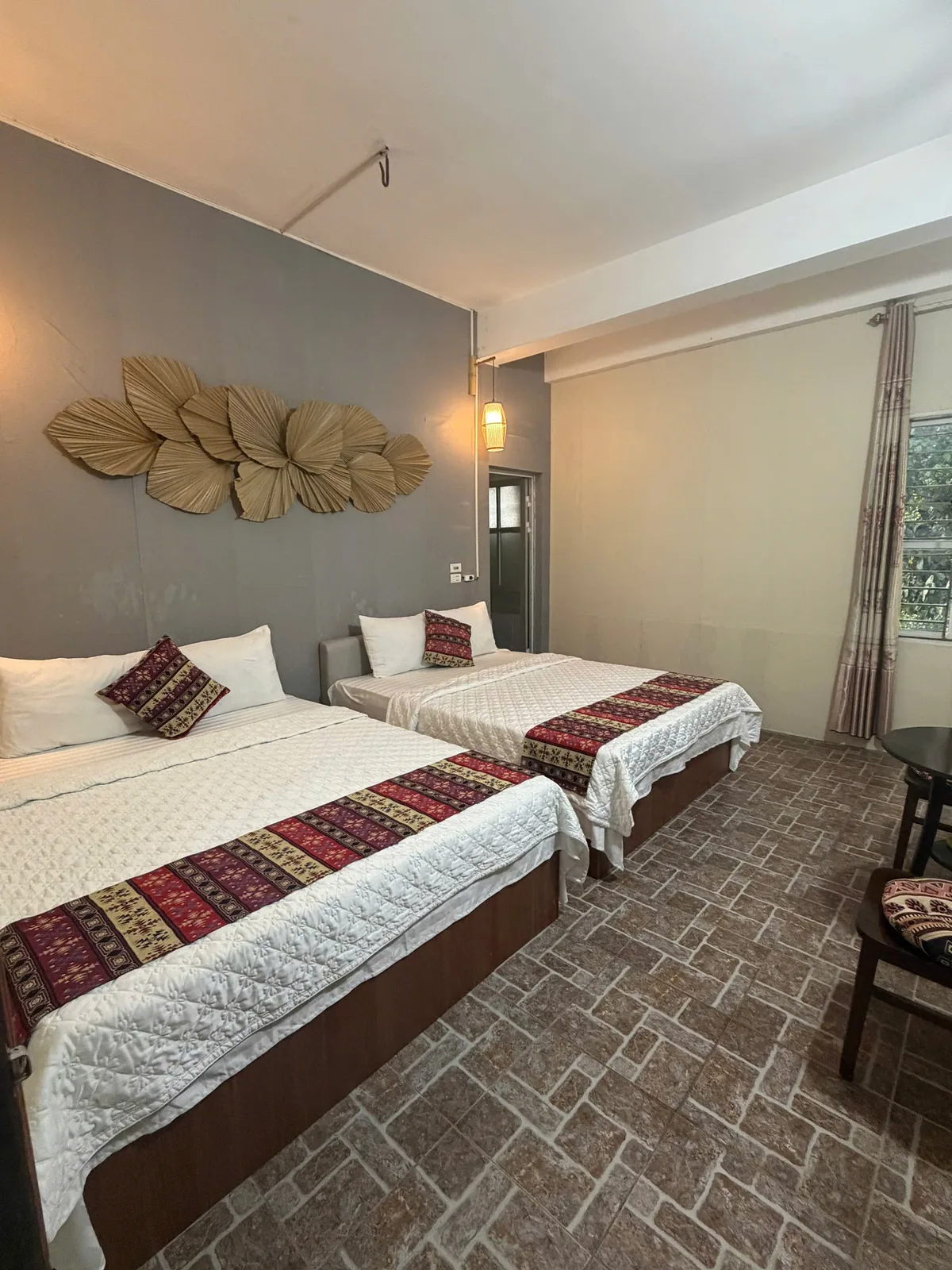 Private room with two large beds, white quilts and woven runners at Freedom in Ha Giang city